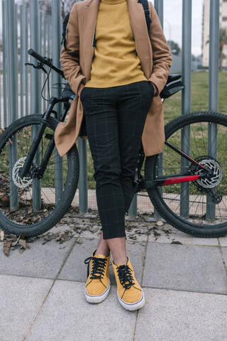 Tiefschnitt eines stilvollen jungen Mannes mit Fahrrad in der Stadt, lizenzfreies Stockfoto
