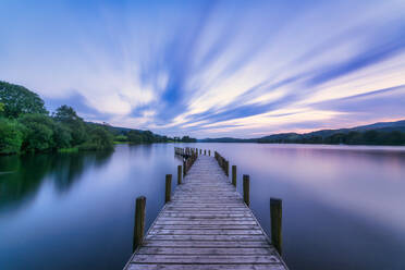 UK, England, Long exposure of clouds over jetty on Coniston Water lake at dusk - SMAF01714