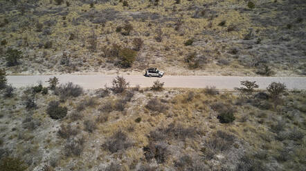 Luftaufnahme eines Jeeps, der eine unbefestigte Piste entlangfährt, Region Damaraland, Namibia - VEGF01422