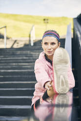 Female runner warming up before workout - ABIF01240