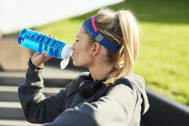 Woman drinking water after hard workout - ABIF01246
