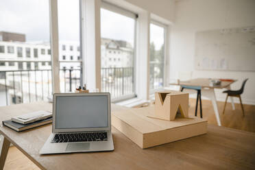 Architectural model and laptop on desk in office - GUSF03174