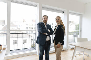 Portrait of confident businessman and businesswoman in office - GUSF03217