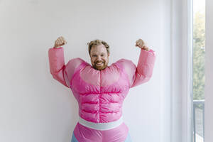 Stolzer Mann in rosa Bodybuilder-Kostüm, der seine Muskeln spielen lässt - GUSF03233