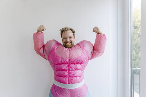 Proud man wearing pink bodybuilder costume flexing his muscles - GUSF03233