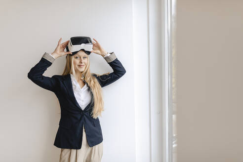Porträt einer jungen Geschäftsfrau mit VR-Brille im Büro - GUSF03255