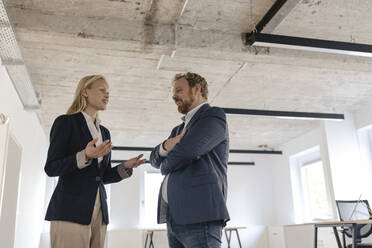 Businessman and businesswoman talking in office - GUSF03273