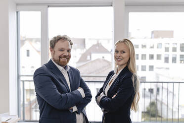 Portrait of confident businessman and businesswoman at the window - GUSF03281