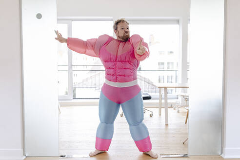 Türsteher im Büro mit rosa Bodybuilder-Kostüm - GUSF03289