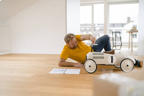 Man playing with toy car - GUSF03290