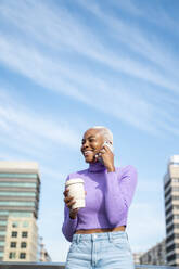 Porträt einer weißhaarigen Frau mit Smartphone und Coffee to go - AFVF05037