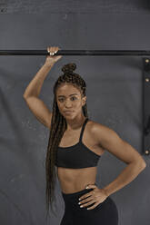 Female athlete standing at chin up bar, looking at camera - VEGF01466