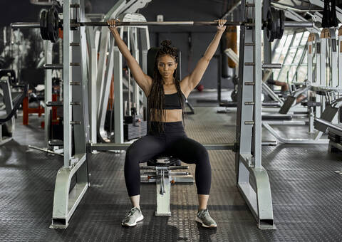 Female athlete weight lifting in gym stock photo