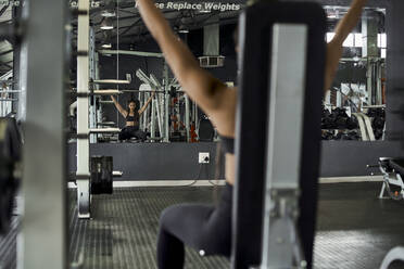 Weibliche Athletin beim Gewichtheben im Fitnessstudio - VEGF01488