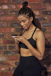 Female athlete using smartphone after workout - VEGF01497