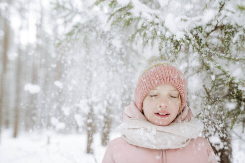 Porträt eines Mädchens mit geschlossenen Augen im Winterwald - EYAF00848