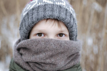 Portrait of boy wearing wool cap and scarf in winter - EYAF00854