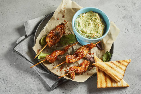 Toasts, grilled chicken skewers and bowl of salsa verde sauce - DREF00040