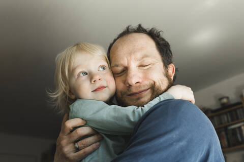 Affectionate father carrying little daughter at home stock photo