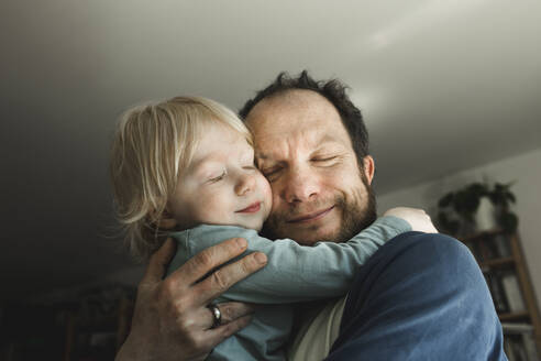 Affectionate father carrying little daughter at home - IHF00261