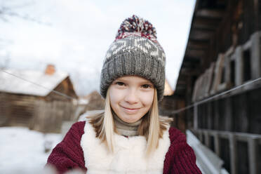 Porträt eines lächelnden Mädchens mit Wollmütze im Winter - EYAF00869