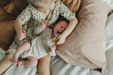 Girl with newborn sibling on bed - JOHF05595