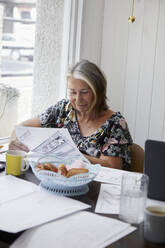 Senior woman doing paperwork - JOHF05612