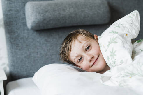 Boy in bed looking at camera - JOHF05700