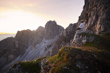 Bergläufer macht eine Pause und beobachtet den Sonnenaufgang in der Axamer Lizum, Österreich - CVF01520