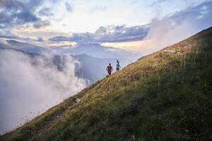 Mann und Frau laufen bergauf in den Bergen - CVF01530