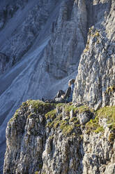 Bergsteiger ruht sich auf einem Felssporn aus und genießt die Aussicht - CVF01545