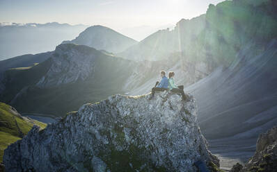 Bergsteiger ruhen sich auf einem Felssporn aus und genießen die Aussicht, Axamer Lizum, Österreich - CVF01557