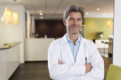 Porträt eines selbstbewussten Arztes in seiner Arztpraxis, lizenzfreies Stockfoto