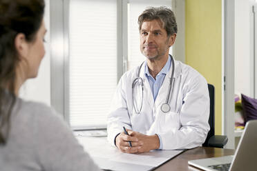 Doctor with female patient in his medical practice - PHDF00052