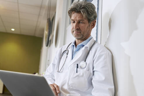 Arzt benutzt Laptop in seiner Praxis - PHDF00065
