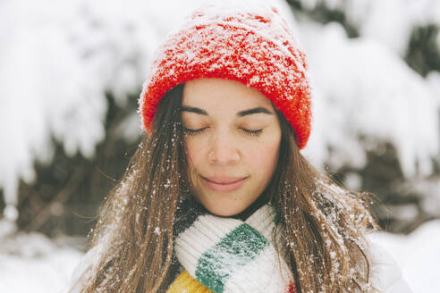 Porträt einer lächelnden Frau mit geschlossenen Augen im Winter - CMSF00076