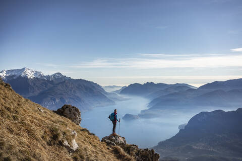 Wanderer auf einem Berg stehend, Blick auf den Comer See, Italien, lizenzfreies Stockfoto