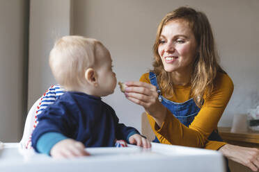 Woman feeding her little son at home - WPEF02463