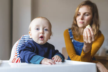 Porträt eines kleinen Jungen mit seiner Mutter im Hochstuhl sitzend - WPEF02464