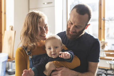 Happy affectionate family in the kitchen at home - WPEF02473