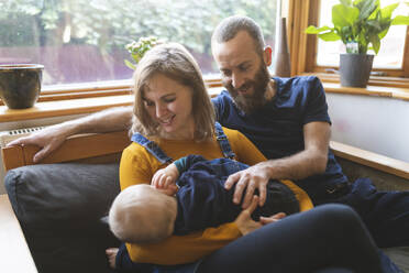 Happy family on the sofa with sleeping little son - WPEF02478