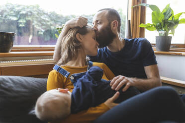 Zärtliche Familie auf dem Sofa mit schlafendem kleinen Sohn - WPEF02479