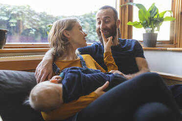 Glückliche Familie auf dem Sofa mit schlafendem kleinen Sohn - WPEF02480