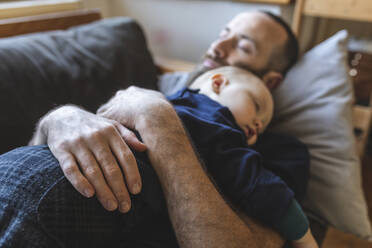 Vater und Sohn schlafen zusammen auf dem Sofa - WPEF02487