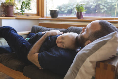 Vater und Sohn schlafen zusammen auf dem Sofa, lizenzfreies Stockfoto