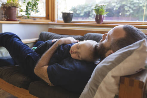 Vater und Sohn schlafen zusammen auf dem Sofa - WPEF02488