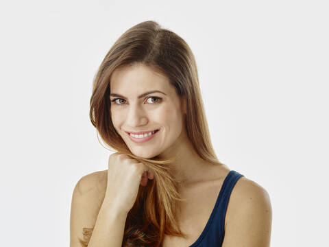 Portrait of smiling woman with long hair against white background stock photo