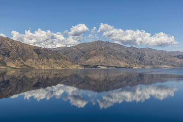 Neuseeland, Queenstown-Lakes District, Wanaka, Hügel und blauer Sommerhimmel spiegeln sich im Hawea-See - FOF11502