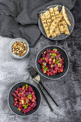 Fladenbrot und Teller mit Rote-Bete-Salat mit Kichererbsen, gerösteten Walnüssen und Petersilie - SARF04440