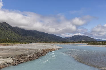 Neuseeland, Westland District, Whataroa, Ufer des Whataroa River mit bewaldeten Bergen im Hintergrund - FOF11530